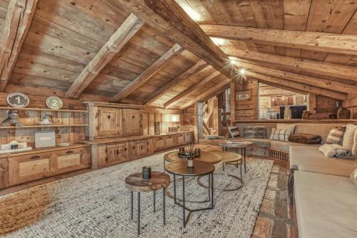 - un salon avec des plafonds et des tables en bois dans l'établissement Chalet Edelweiss, à Megève