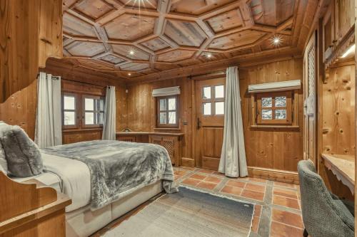 une chambre avec un lit et un plafond en bois dans l'établissement Chalet Edelweiss, à Megève
