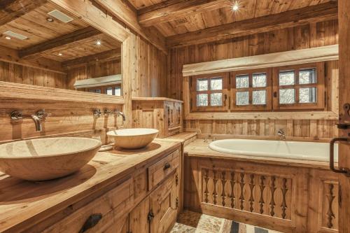 La salle de bains en bois est pourvue de 2 lavabos et d'une baignoire. dans l'établissement Chalet Edelweiss, à Megève