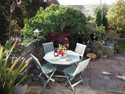 a table and four chairs in a garden at Good stay at 91 in Silsden