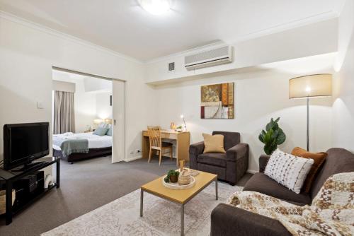 un soggiorno con un divano e una TV di Prized Perth Retreat 1BDR a Perth