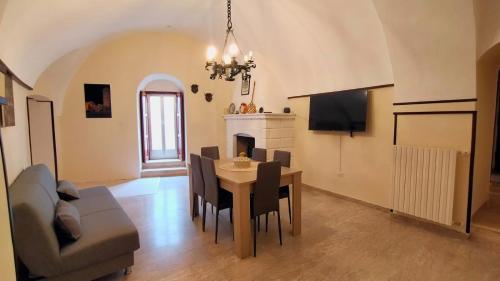 a living room with a dining room table and a couch at Dimora Maggi al Caminetto - Affitti Brevi Italia in Monte SantʼAngelo