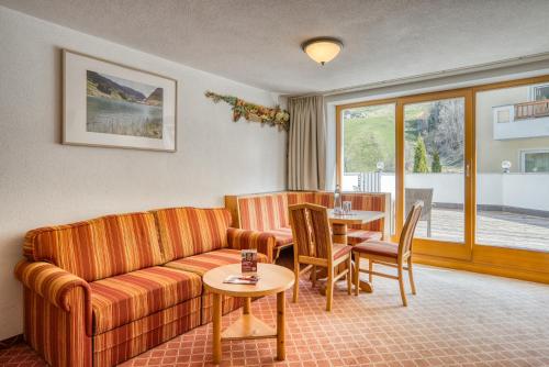 a living room with a couch and a table at Mallaun Hotel.Erlebnis in See