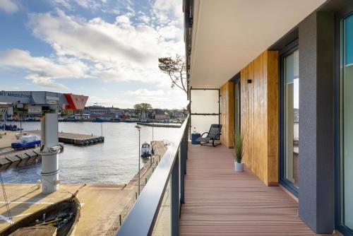 a balcony of a house with a view of the water at Lighthouse Hotel Apartment Next to the Marina by Renters in Mrzeżyno