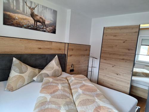 een slaapkamer met een bed met een hert aan de muur bij Haus Waldfriede in Sankt Leonhard im Pitztal