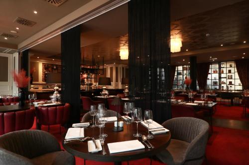 a restaurant with tables and chairs and a bar at Hotel Haverkamp in Bremerhaven
