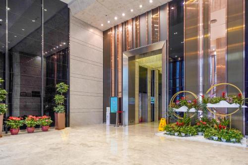 a lobby of a building with potted plants at HT Legend Hotel Changgang Metro Station Exit F - Free Shuttle Bus to Canton Fair Complex During Canton Fair Period in Guangzhou