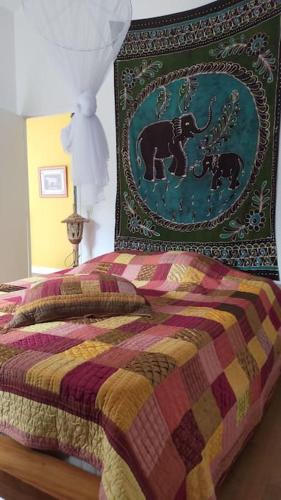 une chambre avec un lit avec une couette colorée dans l'établissement ENTRE LAC ET OCEAN SPACIEUSE ET CALME, à Naujac-sur-Mer