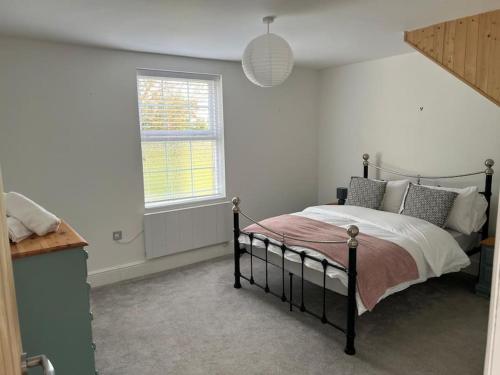 een slaapkamer met een bed en een raam bij 2 bedroom cottage in Old Town in Swindon