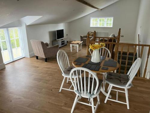 a living room with a wooden table and chairs at 2 bedroom cottage in Old Town in Swindon
