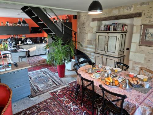 een eetkamer met een tafel met eten erop bij Les Granges de l'Épan in Joue-les-Tours