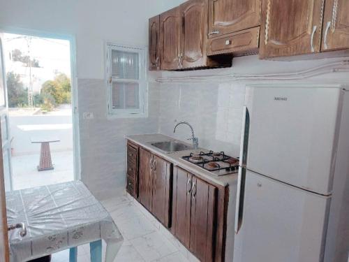 eine Küche mit einem weißen Kühlschrank und einer Spüle in der Unterkunft Blue hostellerie in Le Bardo