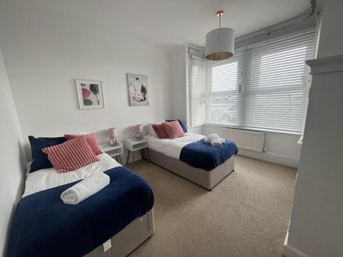 a bedroom with two beds and a window at Stunning 2-Bed Apartment in Shoreham-by-Sea in Shoreham-by-Sea