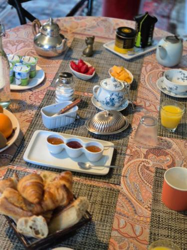 Les Granges de l'Épan في جو لو تورز: طاولة مع وجبة إفطار من الكرواسون وعصير البرتقال