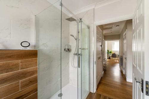 a glass shower in a bathroom with a hallway at Modern and Bright 1 Bed Apartment, Tower Bridge in London
