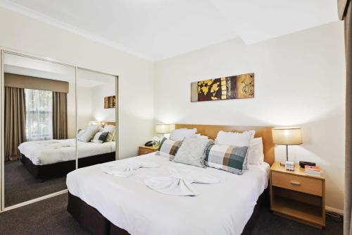 a bedroom with two beds and a large mirror at Northbridge Exclusive Guest Nest in Perth