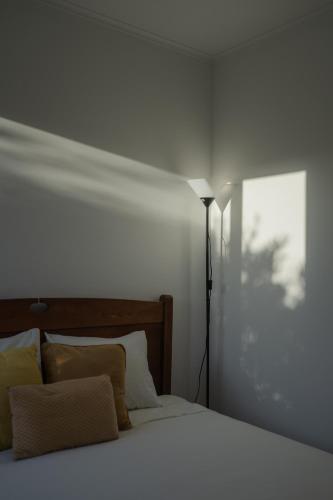 a bedroom with a white bed and a lamp at Quinta do Ferreiro in Ponta Delgada