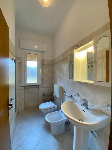 uma casa de banho com um lavatório e um WC em Abruzzi 35 em Cervia
