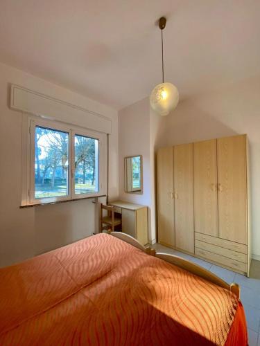 um quarto com uma cama laranja e uma janela em Abruzzi 35 em Cervia