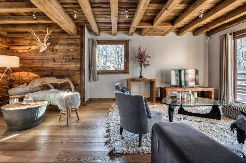 Elle comprend un salon doté d'un mobilier et d'un plafond en bois. dans l'établissement Chalet Eisstock, à Megève