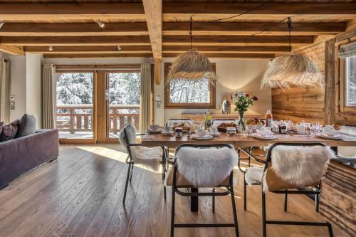 une salle à manger avec une grande table et des chaises en bois dans l'établissement Chalet Eisstock, à Megève