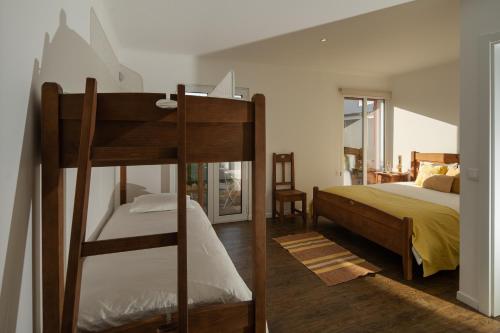 ein Schlafzimmer mit einem Etagenbett und einem Bett in der Unterkunft Quinta do Ferreiro in Ponta Delgada