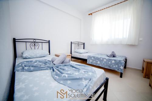 two twin beds in a room with a window at Polys Polychrono MoodSolutions Living in Polykhrono