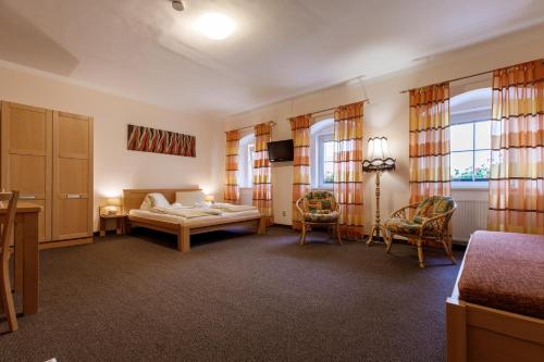um quarto com uma cama, uma mesa e cadeiras em Penzion a Apartmány Daro em Boží Dar