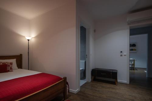 a bedroom with a bed with a red blanket at Quinta do Ferreiro in Ponta Delgada