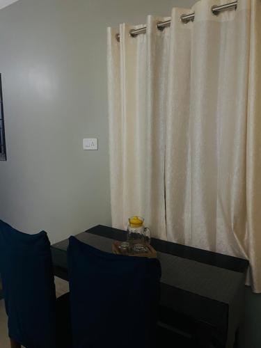 a room with a table and a window with curtains at Renade Leisure Stay in Agartala