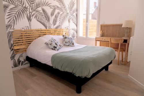 1 dormitorio con 1 cama con 2 almohadas en La Vie En Gîte (Le Cosy), en Sainte-Florence