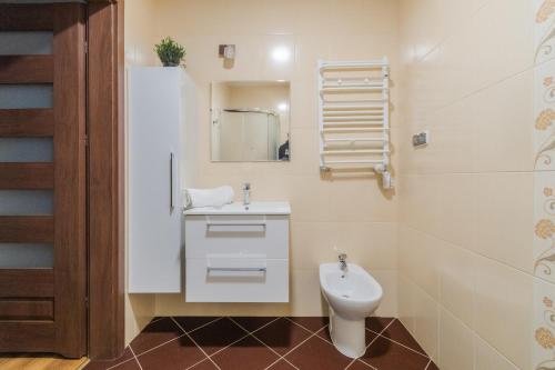 a white bathroom with a sink and a toilet at Apartamenty NCNK przy Marinie w Kątach Rybackich in Kąty Rybackie