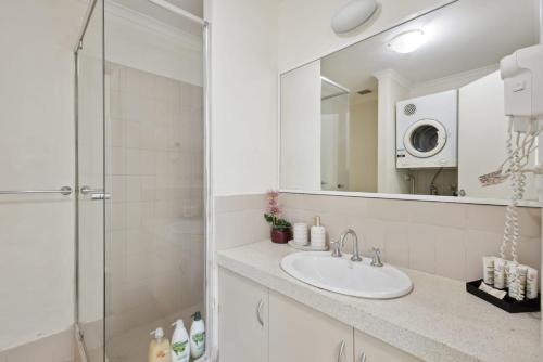 a bathroom with a sink and a shower with a mirror at 3BDR 2BTH 1PRK - Northbridge Townhouse in Perth