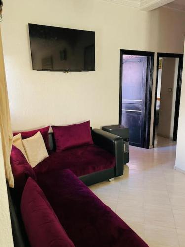 - un salon avec un canapé rouge et une porte dans l'établissement Appartemment meuble شقة مفروشة, à Fès