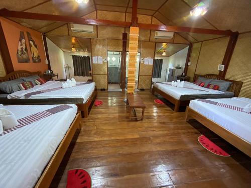 a room with three beds in a room at เชียงคานเรือนไม้ รีสอร์ท in Amphoe Chiang Khan