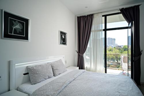 敖德萨Апартаменты в Аркадии - Arcadia Sky Apartments的一间带床和窗户的白色卧室