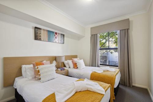 a hotel room with two beds and a window at 2BDR 1BTH 1PRK - Northbridge Magic in Perth