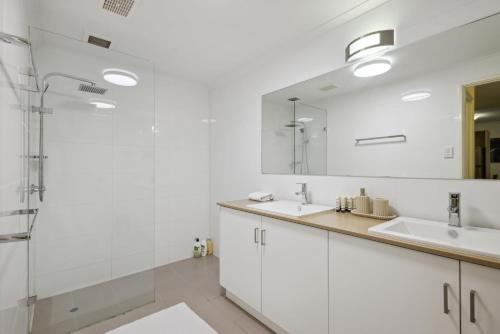 a white bathroom with two sinks and a shower at 2BDR 1BTH 1PRK - Northbridge Magic in Perth