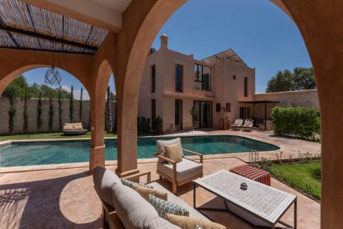 an external view of a villa with a swimming pool at Villa DAR BOUMA in Ghazoua