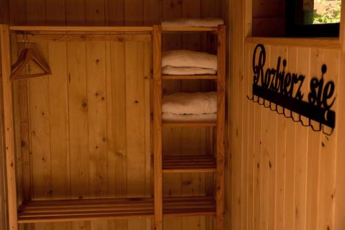 una habitación con una cabaña de madera con 3 estanterías con toallas en Dom z basenem nad Narwia, en Szablak