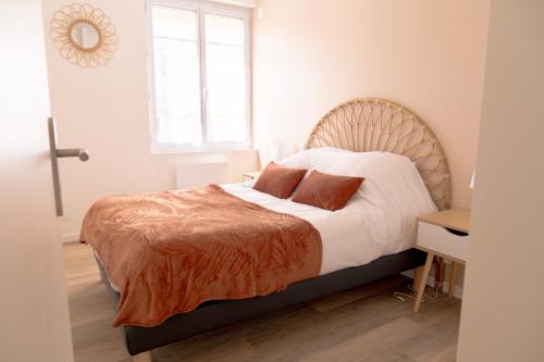 una camera da letto con un letto grande con testiera in legno di La Vie En Gîte (Le Vintage) a Sainte-Florence