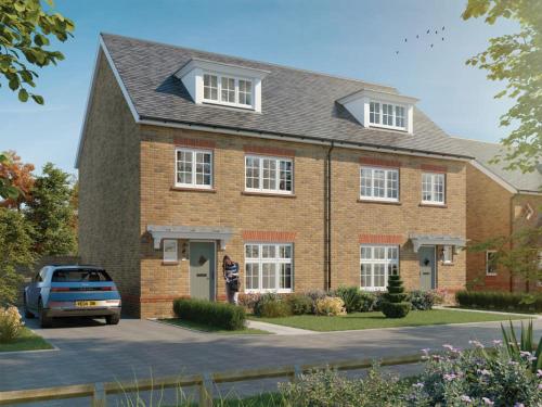 a woman standing in front of a brick house at 3 Bedroom 4 Bathroom House Goodwood Chichester in Chichester