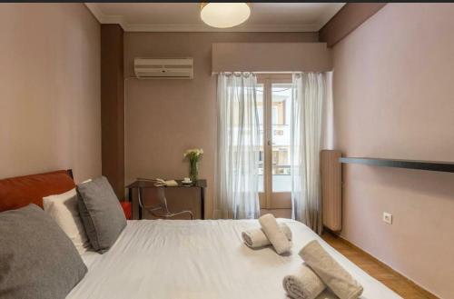 アテネにあるHolodek Apartments Goudi Ground & Semiのベッドルーム1室(白いベッド1台、枕2つ付)