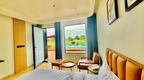 a hotel room with a bed and a chair and a window at Vintclub Resort in Lucknow