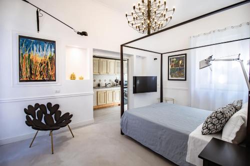 - une chambre avec un lit, une télévision et une chaise dans l'établissement Iommella luxury flat - Schifano, à Sant'Agnello