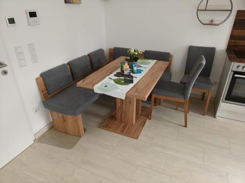 uma mesa de jantar com 4 cadeiras, uma mesa e uma espreguiçadeira em Ferienhaus/Bungalow Monheimer Alb barrierefrei em Monheim