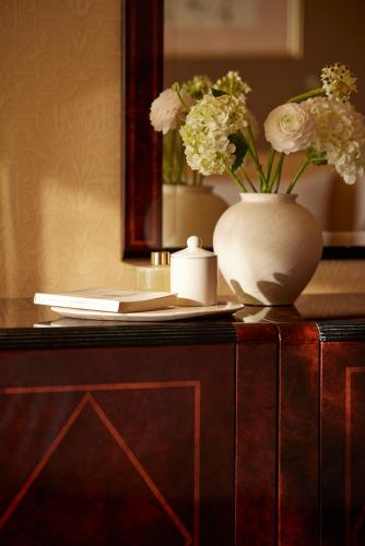a vase with flowers on top of a wooden cabinet at Hotel Panorama in Thessaloniki