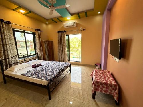 a bedroom with a bed and a flat screen tv at Anand Heritage Villa in Nagaon