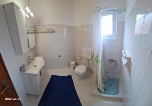 un bagno bianco con lavandino e WC di Gregory-Vassilis Apartments a Dassia