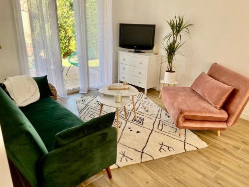 un salon avec un canapé vert et une télévision dans l'établissement Eucalyptus Villa 29, à Argelès-sur-Mer